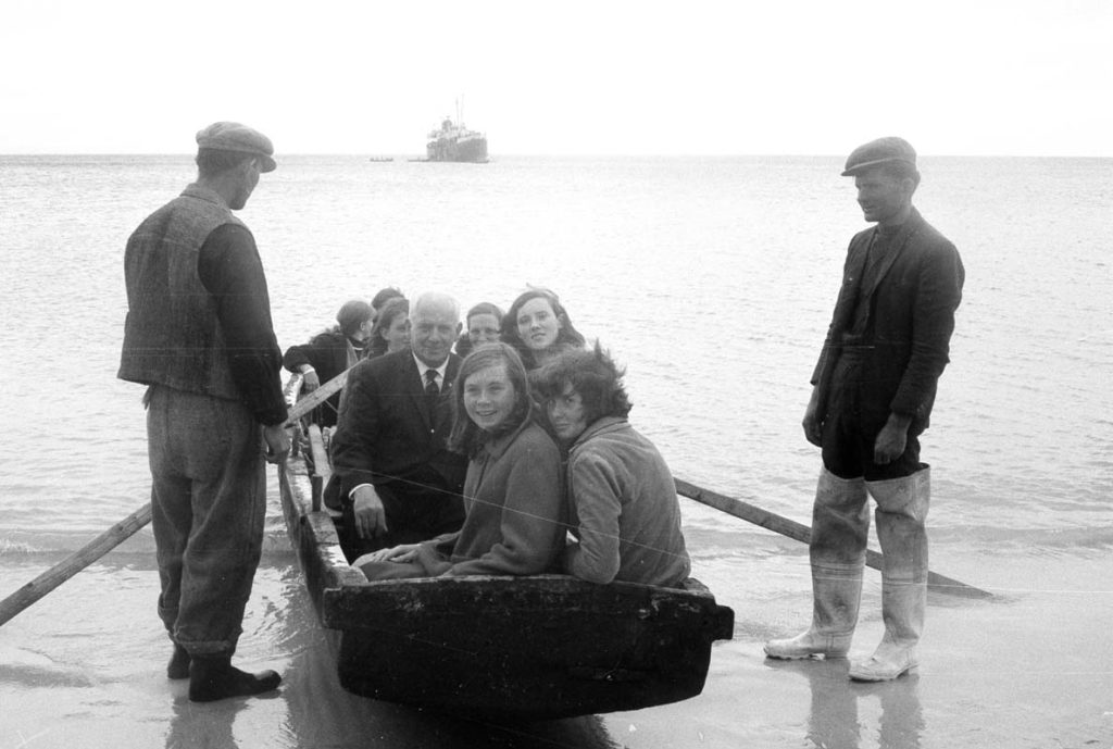 Passengers on way to the waiting Naomh Éanna by currach from Inis Óirr, Aran Islands, County Galway. © National Museum of Ireland.