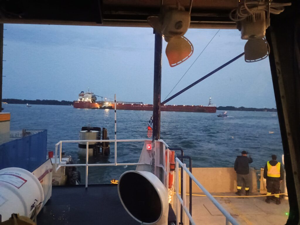 a freighter crossing behind the ferry