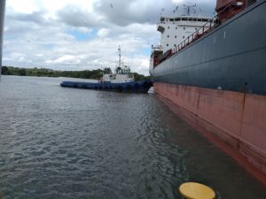 a tugboat pushing a freighter