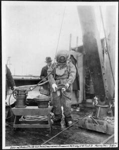 Diver holding a water main joint, 1924. Courtesy of the Seattle Municipal Archive. Image ID 6119